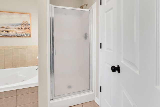 full bath featuring a shower stall, a tub with jets, and tile patterned flooring