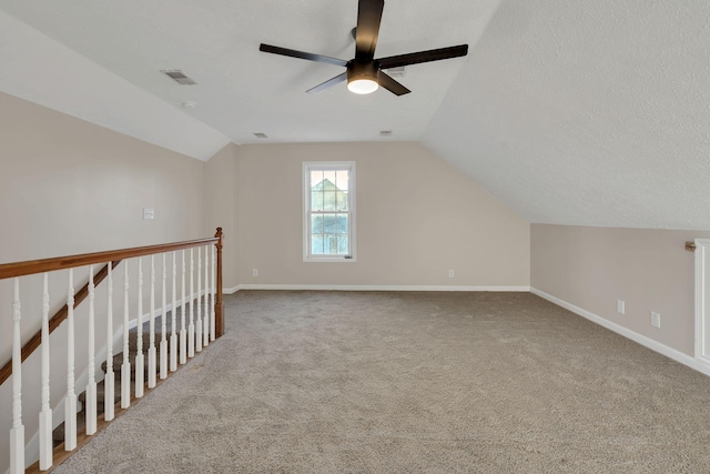 bonus room with visible vents, carpet flooring, vaulted ceiling, a textured ceiling, and baseboards