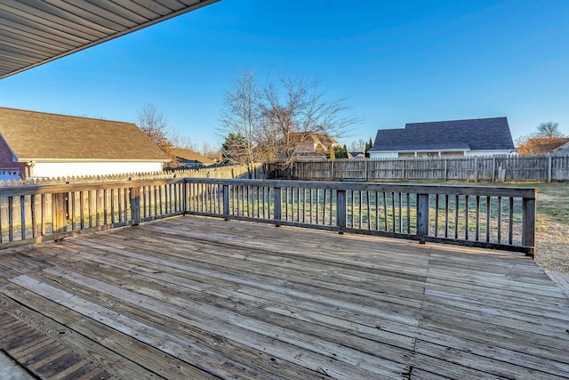 wooden terrace with a fenced backyard