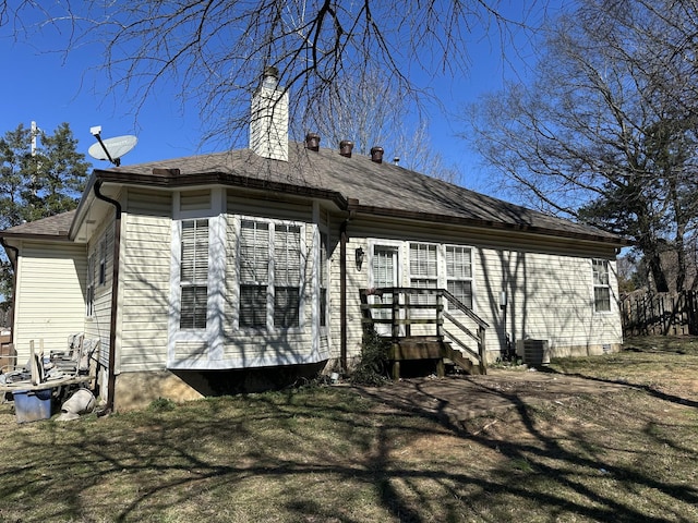 rear view of property with central AC and a shingled roof