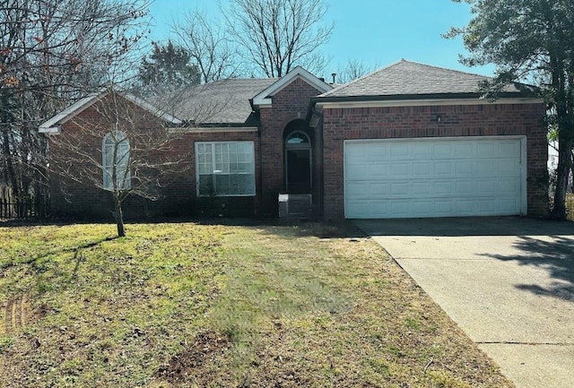 ranch-style home featuring driveway, a shingled roof, an attached garage, a front lawn, and brick siding