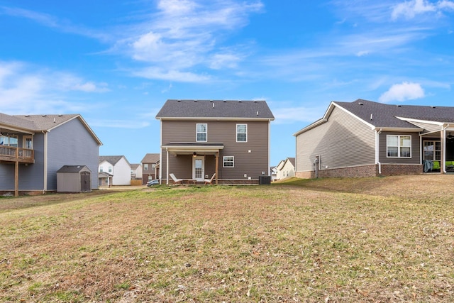 rear view of house featuring central AC, a lawn, an outdoor structure, and a shed