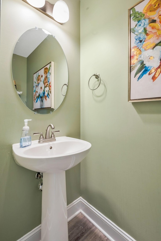 bathroom with a sink, baseboards, and wood finished floors