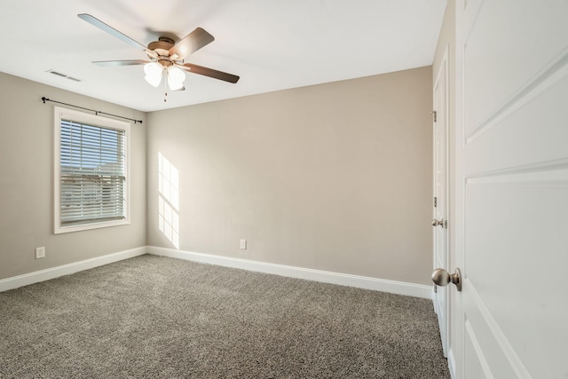 carpeted empty room featuring ceiling fan, visible vents, and baseboards