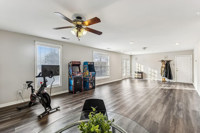 workout room with visible vents, ceiling fan, baseboards, and wood finished floors