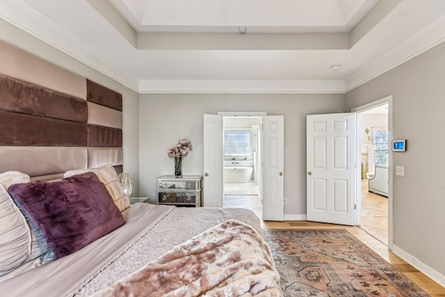 bedroom with baseboards, a tray ceiling, and ornamental molding