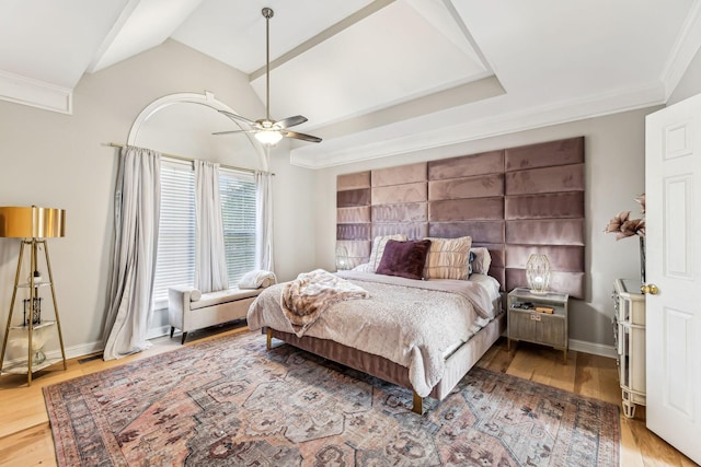 bedroom featuring ornamental molding, lofted ceiling, baseboards, and wood finished floors