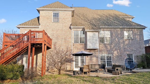 back of house with a patio area, brick siding, stairway, and roof with shingles