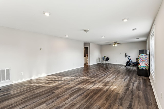 empty room with dark wood-style floors, a healthy amount of sunlight, visible vents, and baseboards