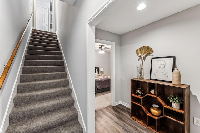 stairway featuring ceiling fan, baseboards, wood finished floors, and recessed lighting