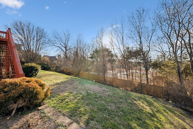 view of yard with fence and stairs