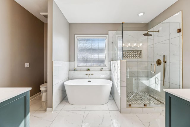 full bath with marble finish floor, a soaking tub, a marble finish shower, and vanity