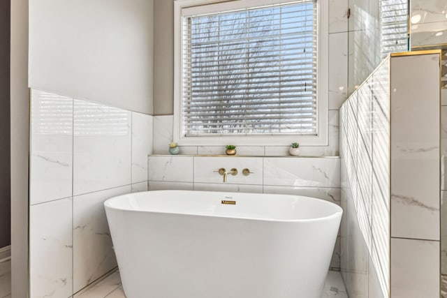 bathroom with a freestanding tub and a wealth of natural light