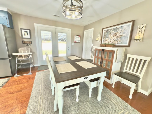 dining area featuring french doors, visible vents, baseboards, and wood finished floors