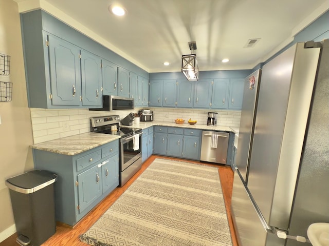 kitchen featuring tasteful backsplash, light wood-style flooring, visible vents, and stainless steel appliances