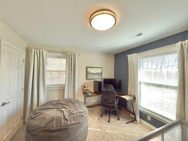 carpeted office space featuring baseboards, visible vents, and wallpapered walls