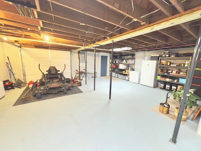 unfinished below grade area featuring washer and dryer and freestanding refrigerator