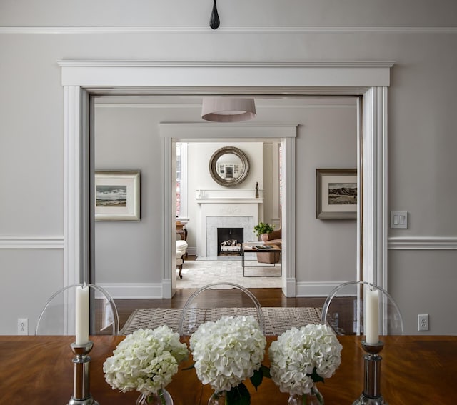 dining room featuring a fireplace, baseboards, and wood finished floors