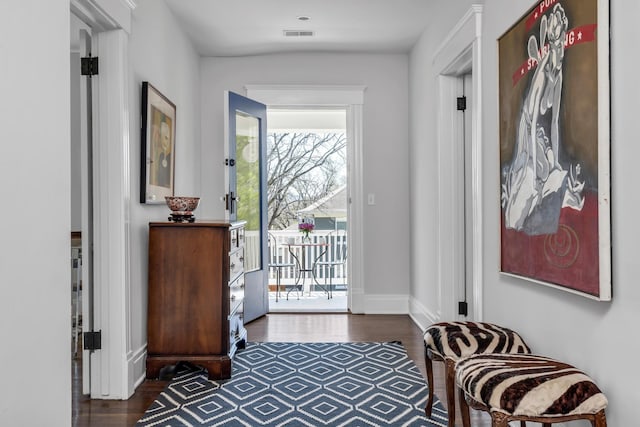 entryway with wood finished floors, visible vents, and baseboards