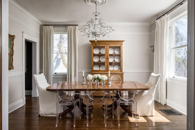 dining room featuring baseboards, visible vents, dark wood finished floors, ornamental molding, and a notable chandelier