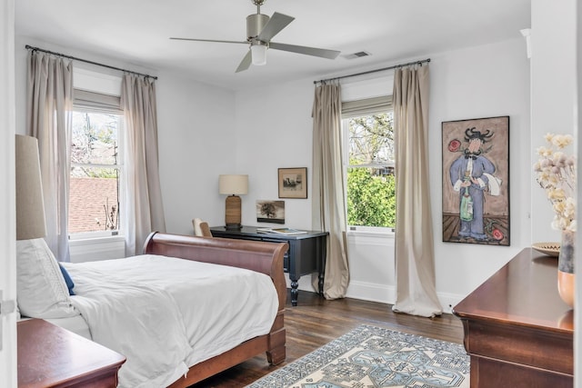 bedroom featuring multiple windows, dark wood finished floors, visible vents, and baseboards