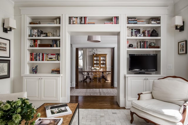 sitting room with built in shelves and wood finished floors