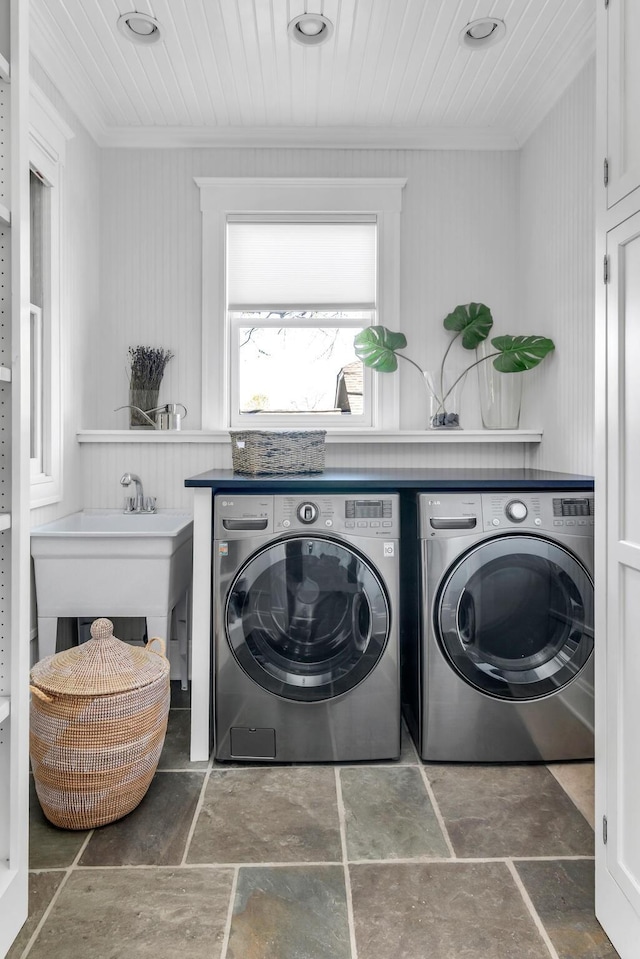 laundry room with crown molding, stone finish floor, a sink, wooden ceiling, and independent washer and dryer