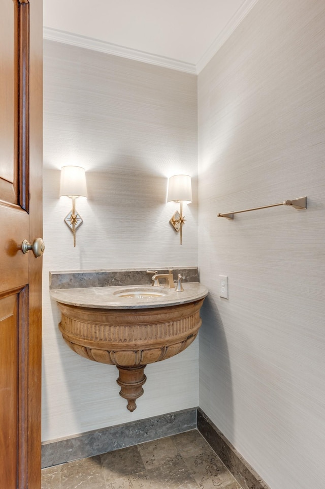 bathroom featuring stone finish flooring, ornamental molding, and baseboards