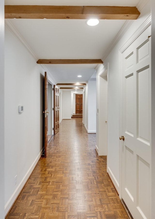 hallway featuring baseboards, beamed ceiling, and ornamental molding