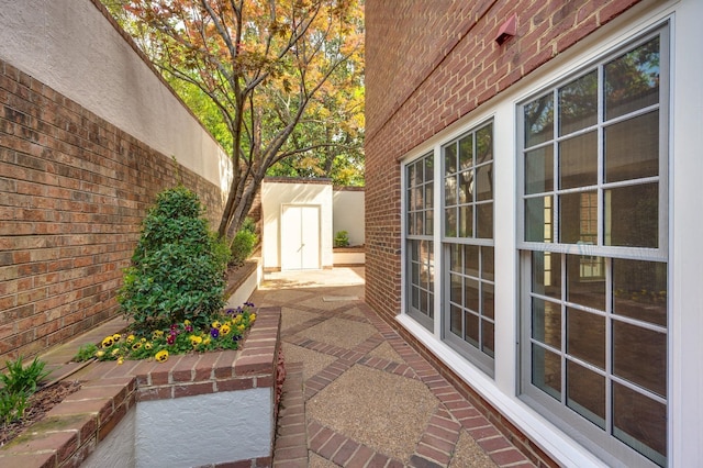 view of patio with a storage unit, an outdoor structure, and fence