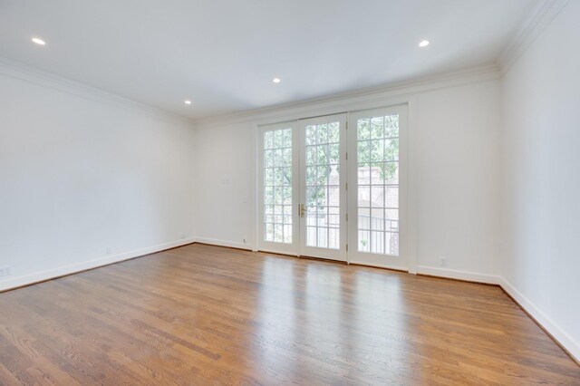 spare room featuring recessed lighting, crown molding, baseboards, and wood finished floors