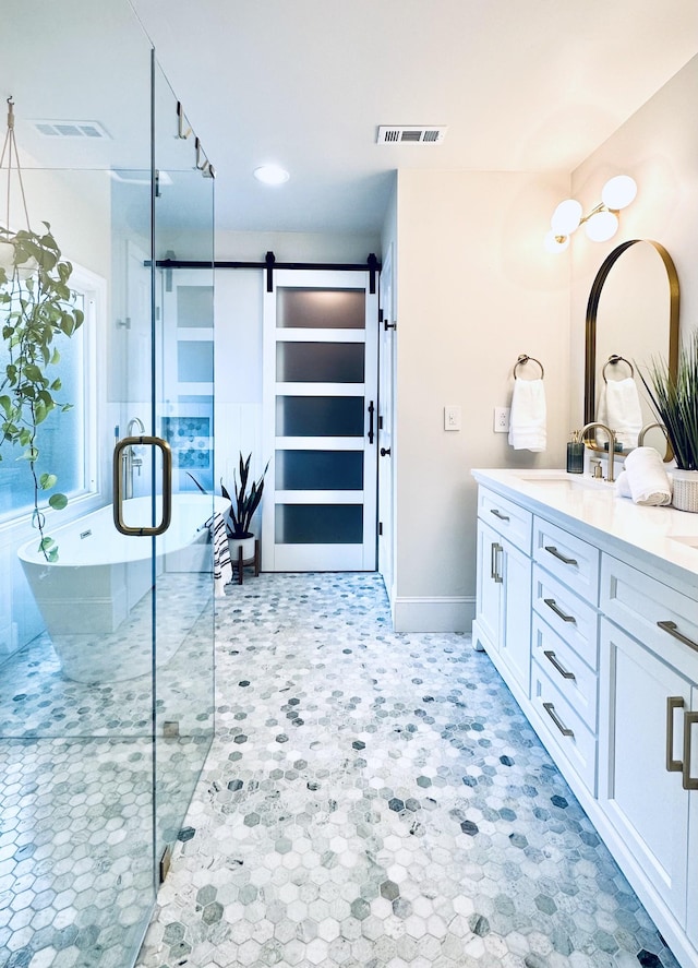 full bathroom featuring a freestanding tub, a shower stall, visible vents, and vanity