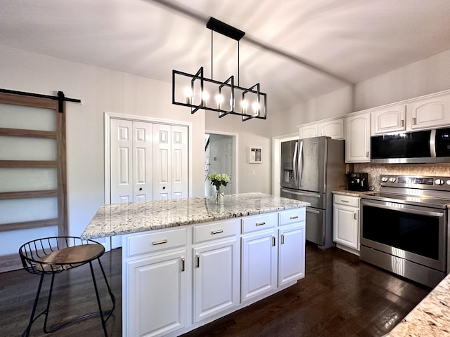 kitchen featuring dark wood-type flooring, a center island, white cabinetry, appliances with stainless steel finishes, and decorative backsplash