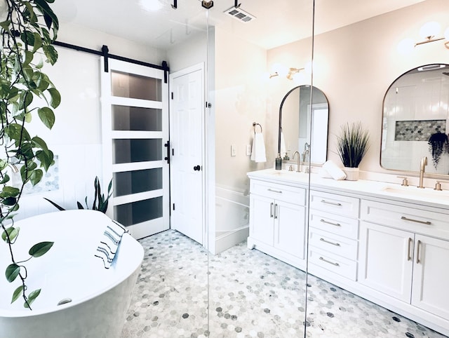 bathroom featuring a soaking tub, visible vents, a sink, and double vanity