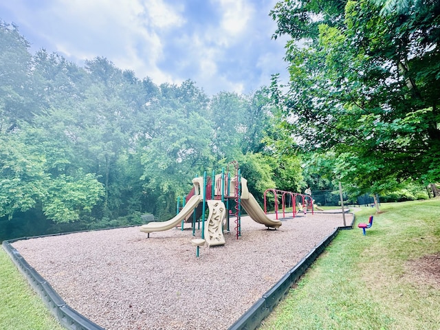 community jungle gym featuring a lawn