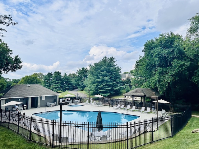 pool with a gazebo, fence, and a patio