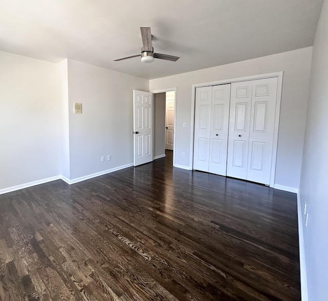 unfurnished bedroom with dark wood-style flooring, a closet, a ceiling fan, and baseboards