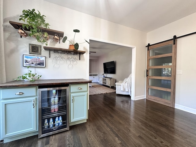 bar with wine cooler, a barn door, baseboards, dark wood-style floors, and a bar