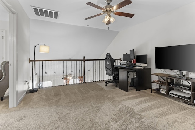 carpeted office space with lofted ceiling, visible vents, and a ceiling fan