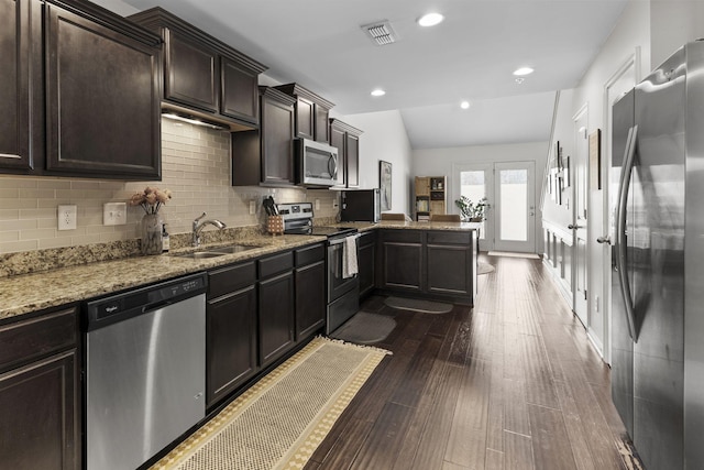 kitchen featuring visible vents, appliances with stainless steel finishes, dark wood-type flooring, a sink, and a peninsula