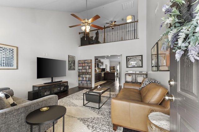 living room with ceiling fan, high vaulted ceiling, wood finished floors, and visible vents