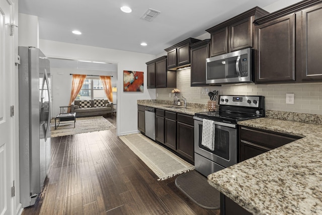 kitchen featuring stainless steel appliances, dark wood-style flooring, visible vents, dark brown cabinets, and tasteful backsplash