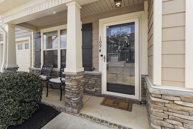 property entrance featuring a porch and stone siding