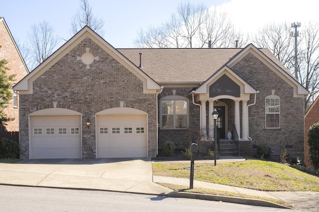 view of front facade with a garage, driveway, brick siding, and crawl space