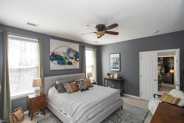 bedroom featuring light colored carpet, visible vents, baseboards, and multiple windows