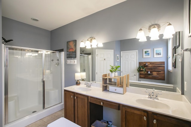 full bathroom with double vanity, a stall shower, tile patterned flooring, and a sink