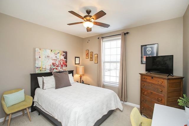 bedroom with a ceiling fan, light carpet, and baseboards