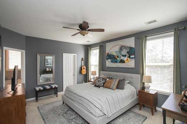 bedroom with baseboards, visible vents, ceiling fan, and light colored carpet