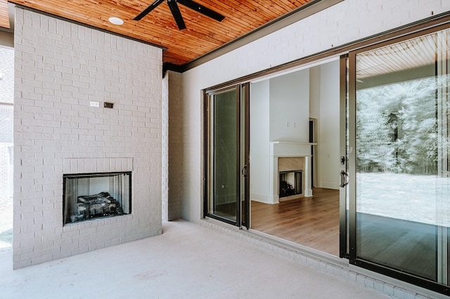 view of patio featuring a ceiling fan and a fireplace