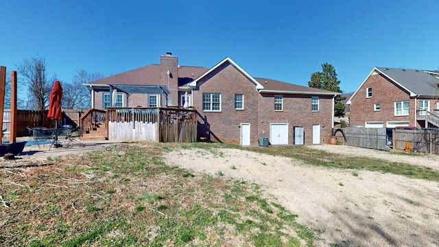 rear view of house with cooling unit, brick siding, a chimney, and a fenced backyard